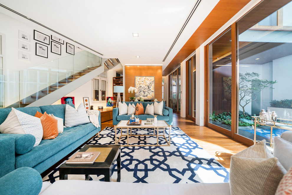Idee per un soggiorno etnico aperto con sala formale, pareti bianche, pavimento in legno massello medio e pavimento marrone