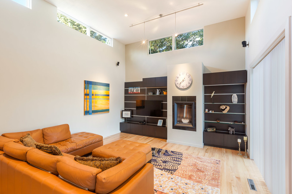 Trendy medium tone wood floor living room photo in Denver with beige walls