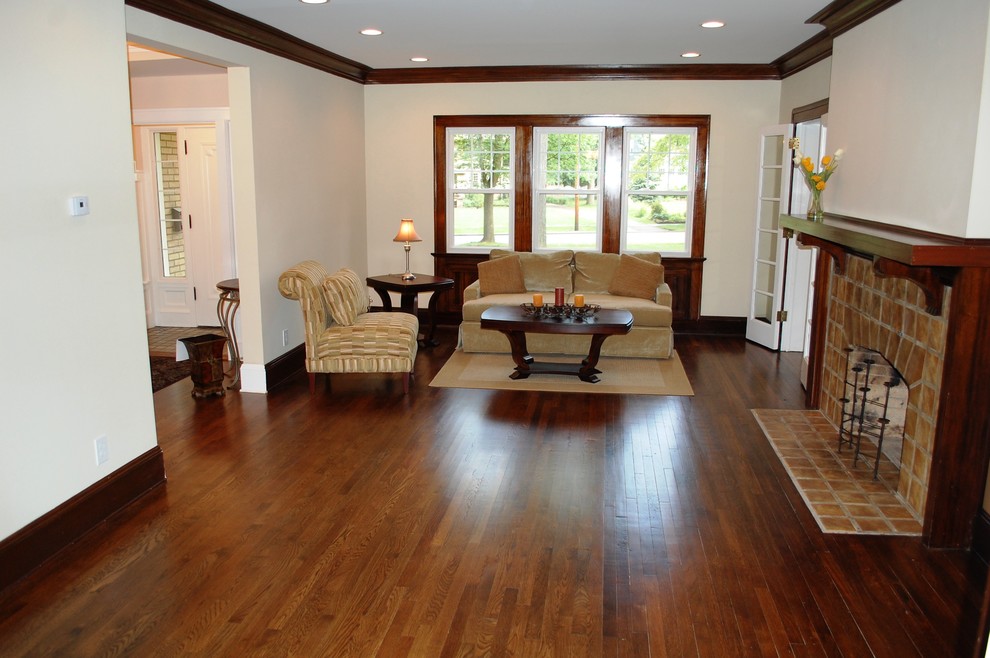 Example of a huge classic enclosed dark wood floor living room design in Cleveland with beige walls, a standard fireplace and a tile fireplace