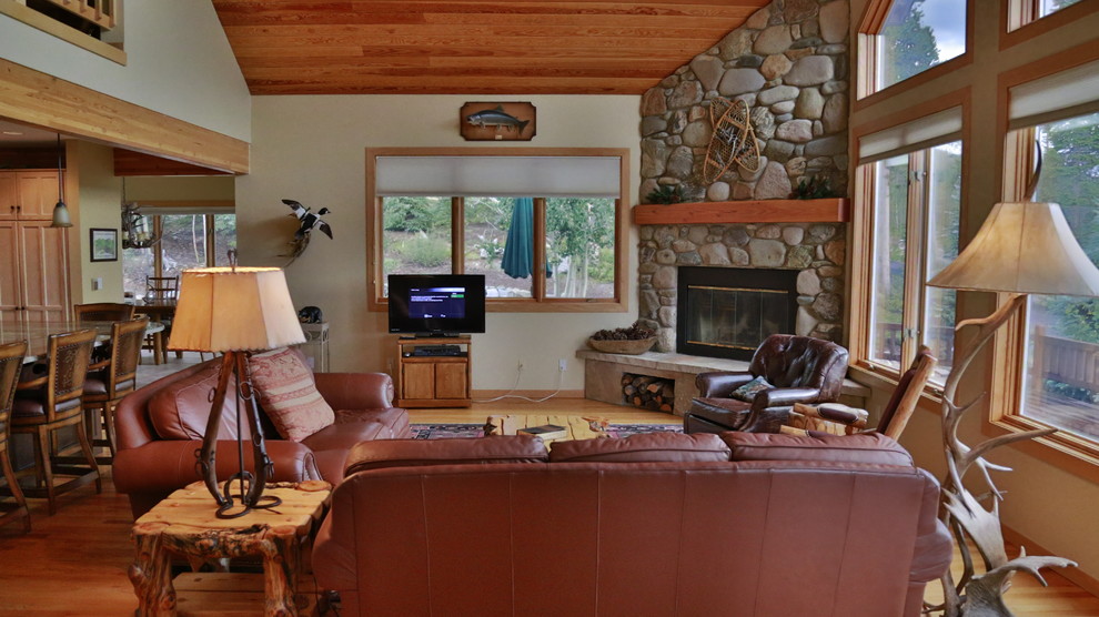 Bild på ett stort funkis allrum med öppen planlösning, med beige väggar, mellanmörkt trägolv, en öppen hörnspis, en spiselkrans i sten och en fristående TV