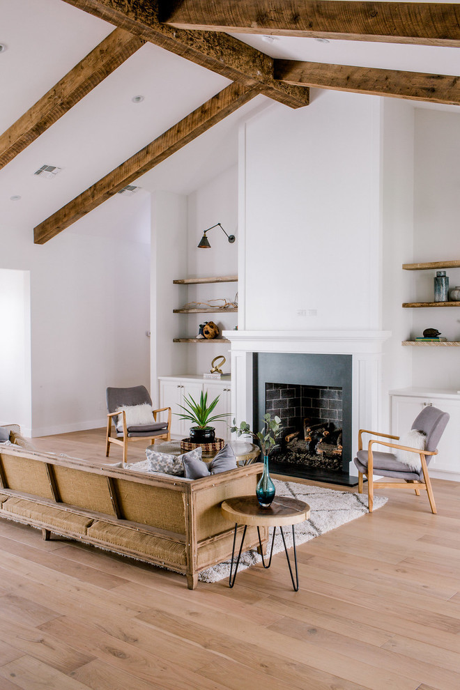 Imagen de salón para visitas abierto campestre sin televisor con paredes blancas, suelo de madera clara, todas las chimeneas, marco de chimenea de ladrillo y suelo beige