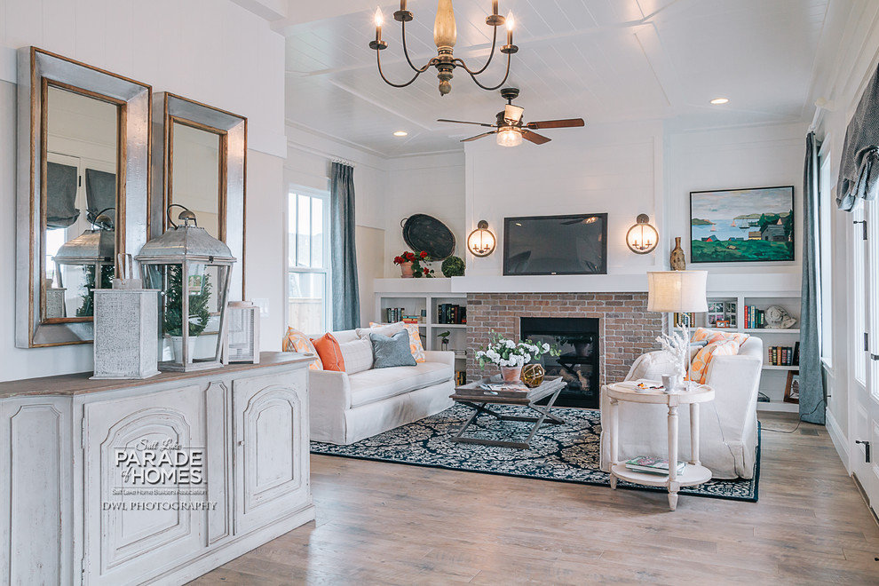 Inspiration for a medium sized traditional enclosed living room in Salt Lake City with beige walls, medium hardwood flooring, a standard fireplace, a brick fireplace surround and a wall mounted tv.