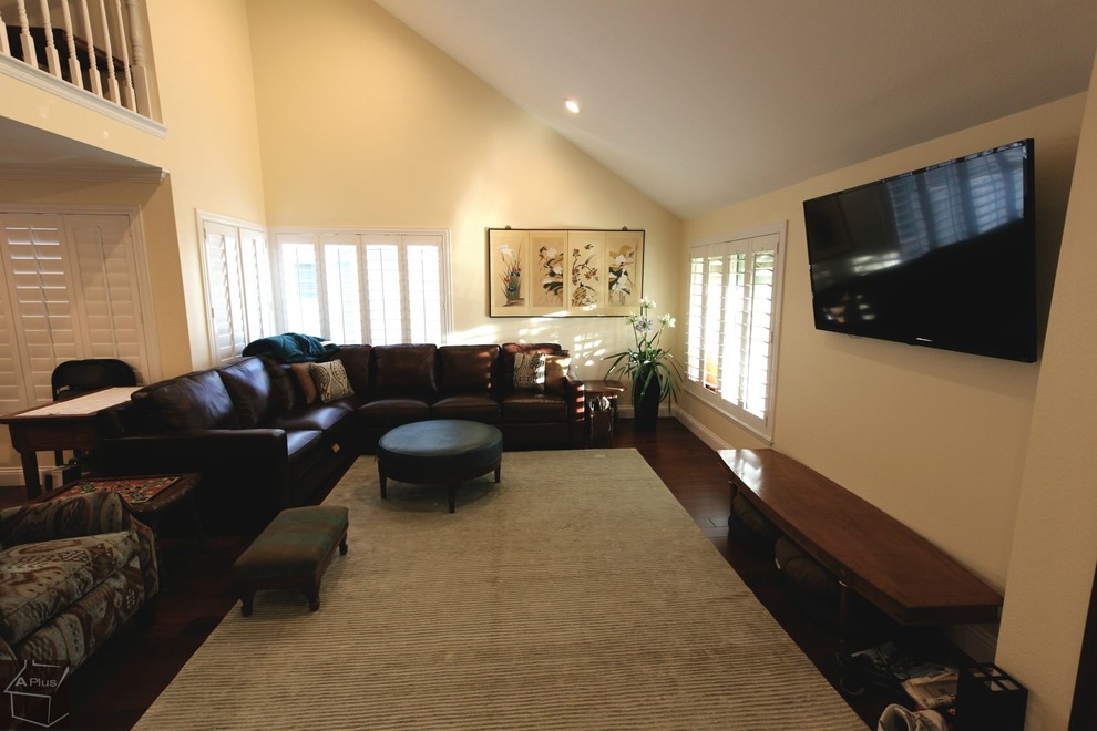 Esempio di un grande soggiorno tradizionale stile loft con sala formale, pareti beige, parquet scuro, nessun camino e TV a parete