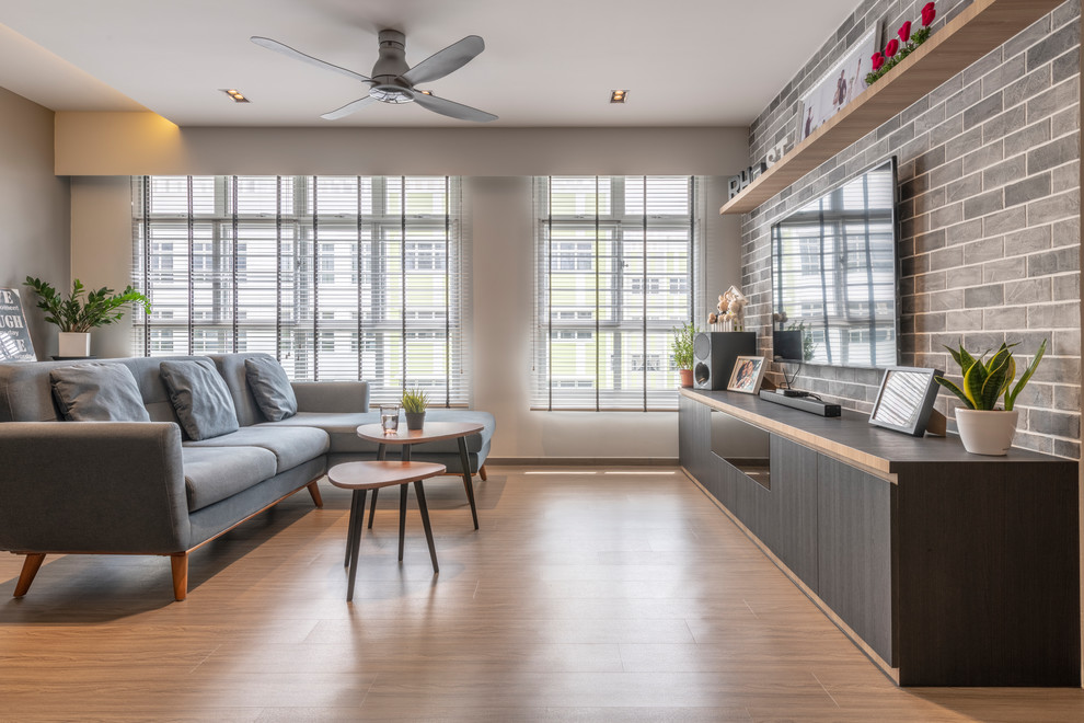 Ispirazione per un soggiorno design con pareti grigie, parquet chiaro, TV a parete e pavimento beige