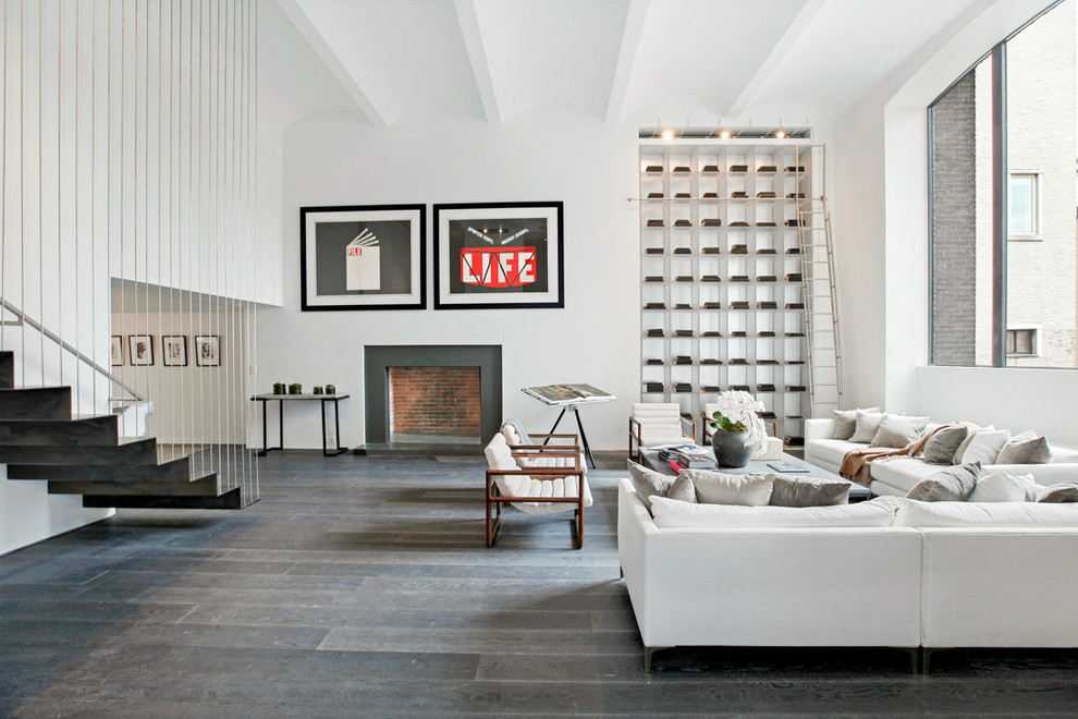 Diseño de salón abierto contemporáneo con paredes blancas, suelo de madera oscura, todas las chimeneas, marco de chimenea de yeso y suelo marrón