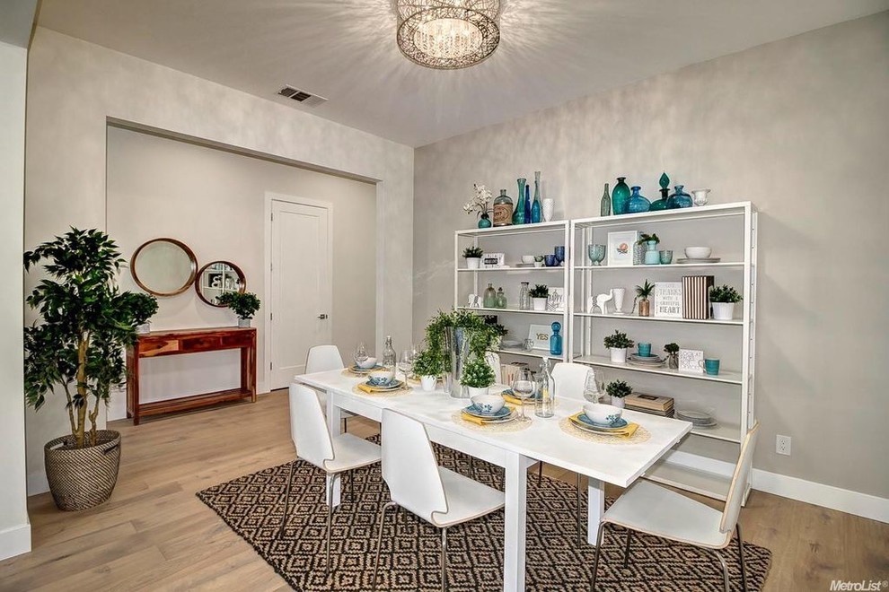 Inspiration pour une salle à manger design de taille moyenne avec un mur blanc, parquet clair, une cheminée standard, un manteau de cheminée en carrelage et un sol beige.