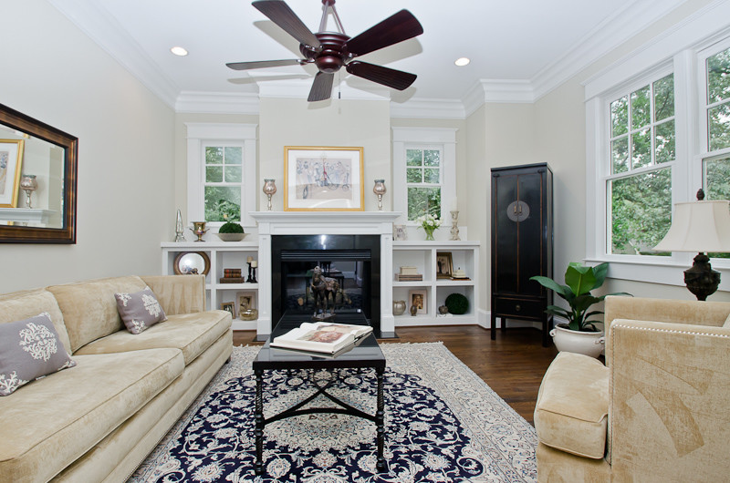 This is an example of a large traditional formal enclosed living room in Atlanta with beige walls, medium hardwood flooring, a standard fireplace, a stone fireplace surround and a wall mounted tv.