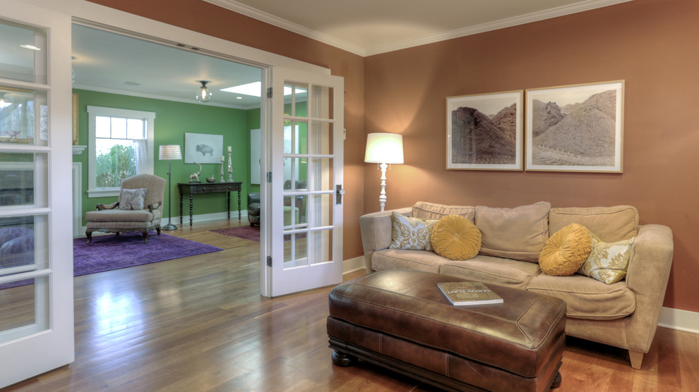 Идея дизайна: открытая гостиная комната среднего размера в стиле кантри с с книжными шкафами и полками, коричневыми стенами и паркетным полом среднего тона
