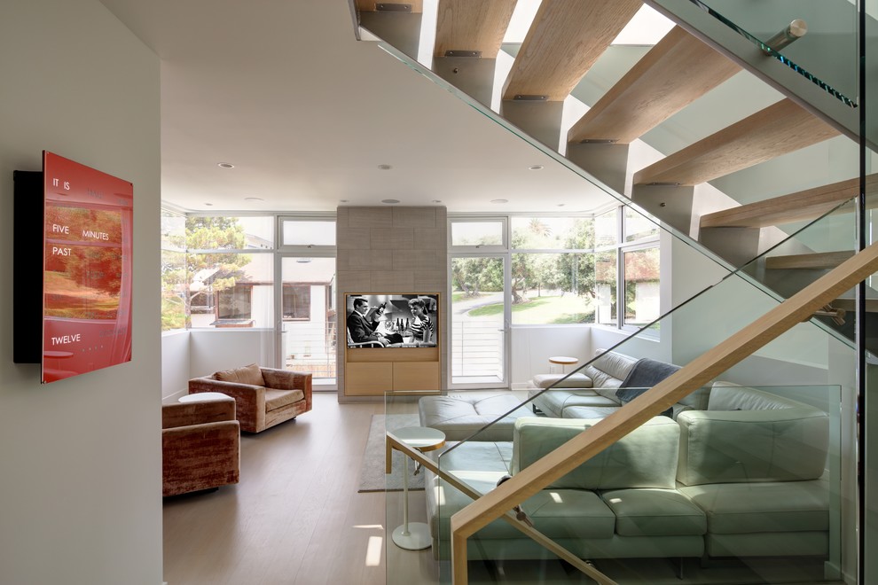 Offenes Skandinavisches Wohnzimmer mit weißer Wandfarbe, hellem Holzboden, TV-Wand und beigem Boden in Los Angeles