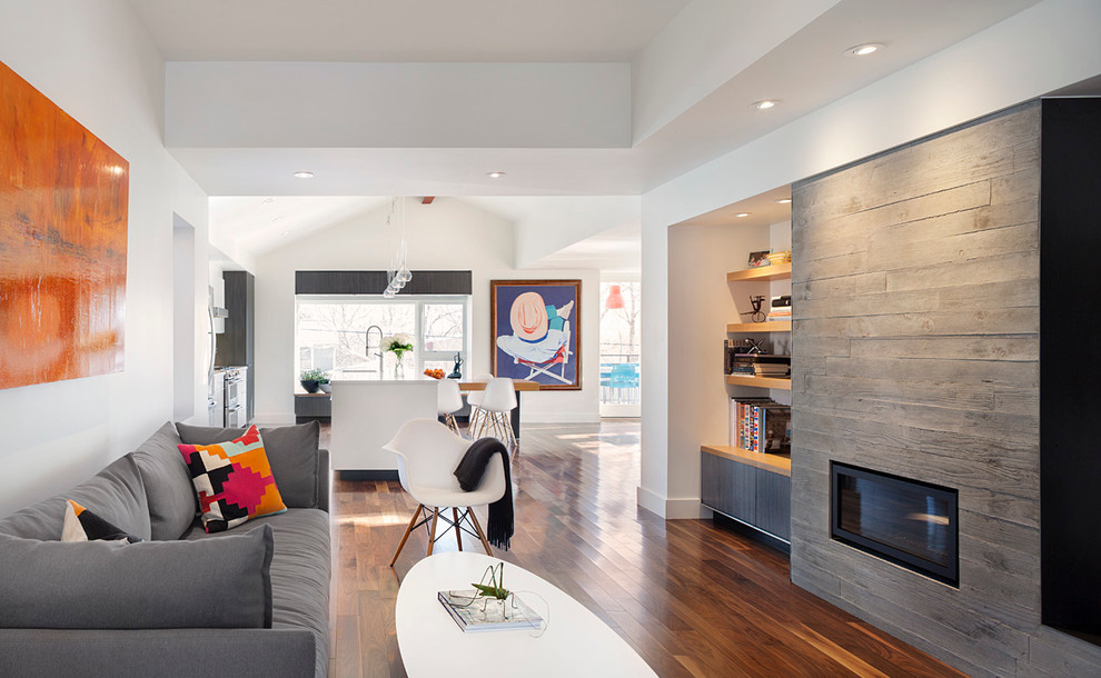 Repräsentatives, Offenes Modernes Wohnzimmer mit weißer Wandfarbe, braunem Holzboden, Gaskamin und Kaminumrandung aus Holz in Denver