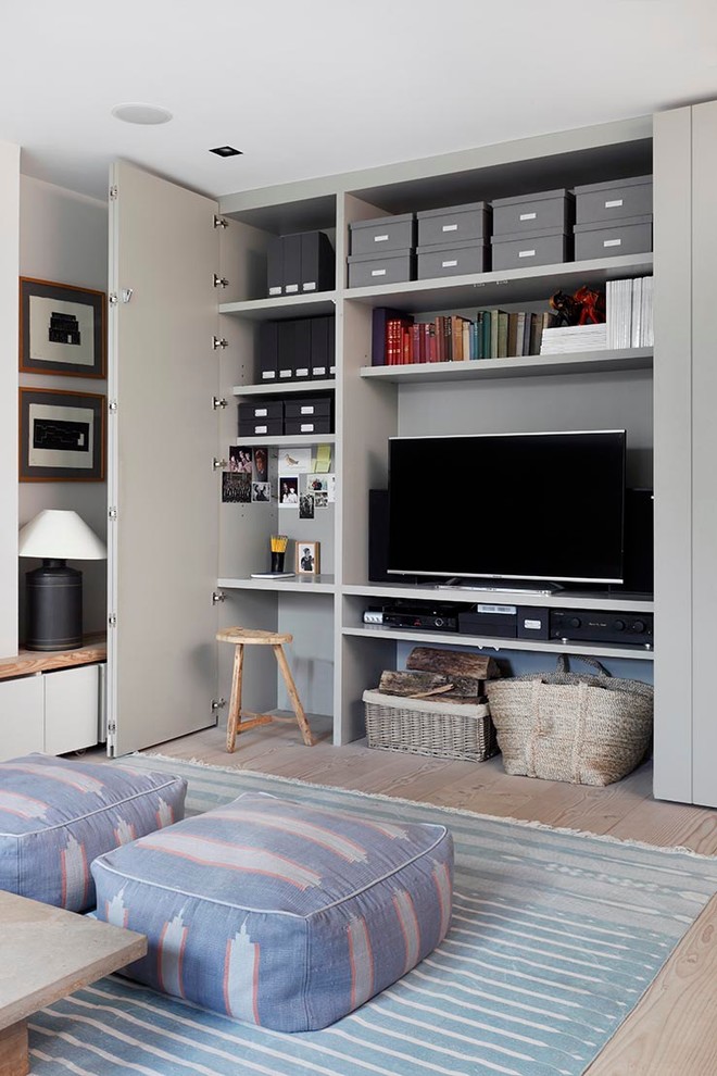 Living room - transitional light wood floor living room idea in London with gray walls and a media wall