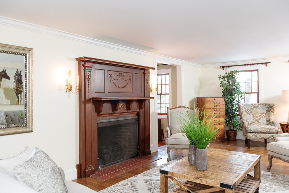 Inspiration for a large traditional enclosed living room in Boston with a reading nook, medium hardwood flooring, a standard fireplace and a wooden fireplace surround.