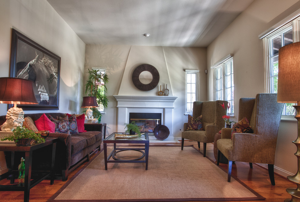 This is an example of a large traditional formal enclosed living room in San Francisco with beige walls, dark hardwood flooring, a standard fireplace, a wooden fireplace surround and no tv.