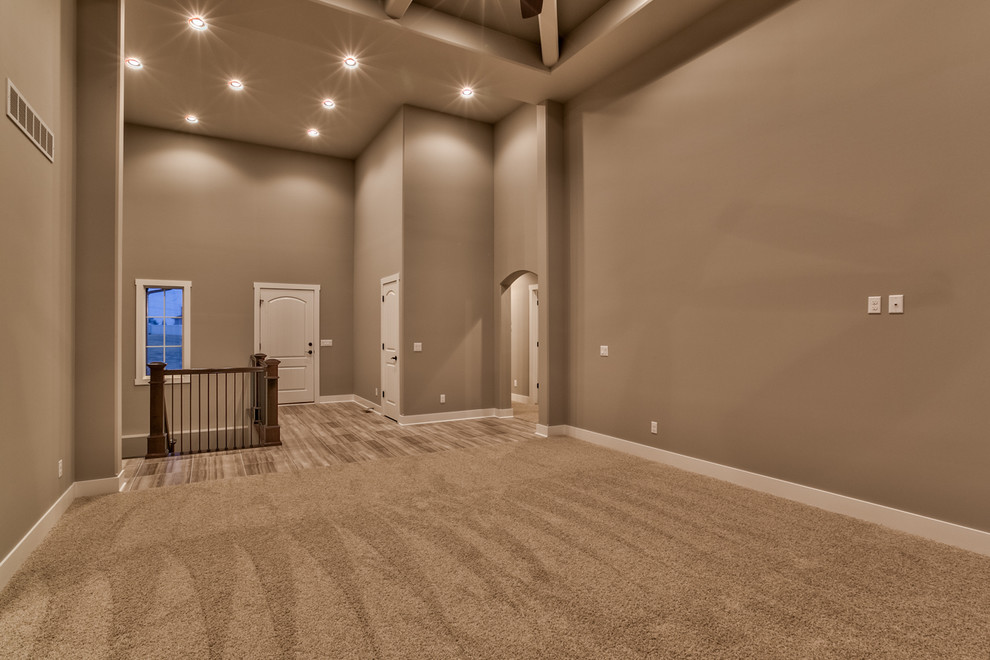 Идея дизайна: большая открытая гостиная комната в средиземноморском стиле с серыми стенами, ковровым покрытием, двусторонним камином и фасадом камина из камня без телевизора