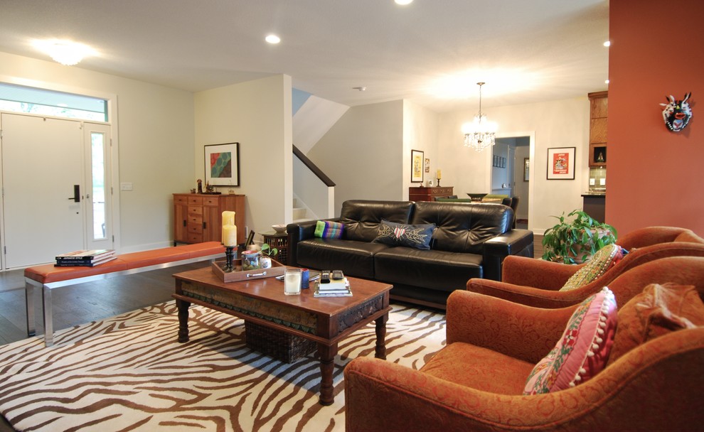 Ispirazione per un soggiorno moderno di medie dimensioni e stile loft con pareti arancioni, parquet scuro, camino classico e TV a parete