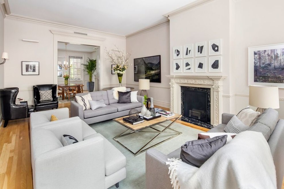 Immagine di un soggiorno chic chiuso con pareti beige, camino classico, TV a parete, parquet chiaro e pavimento arancione