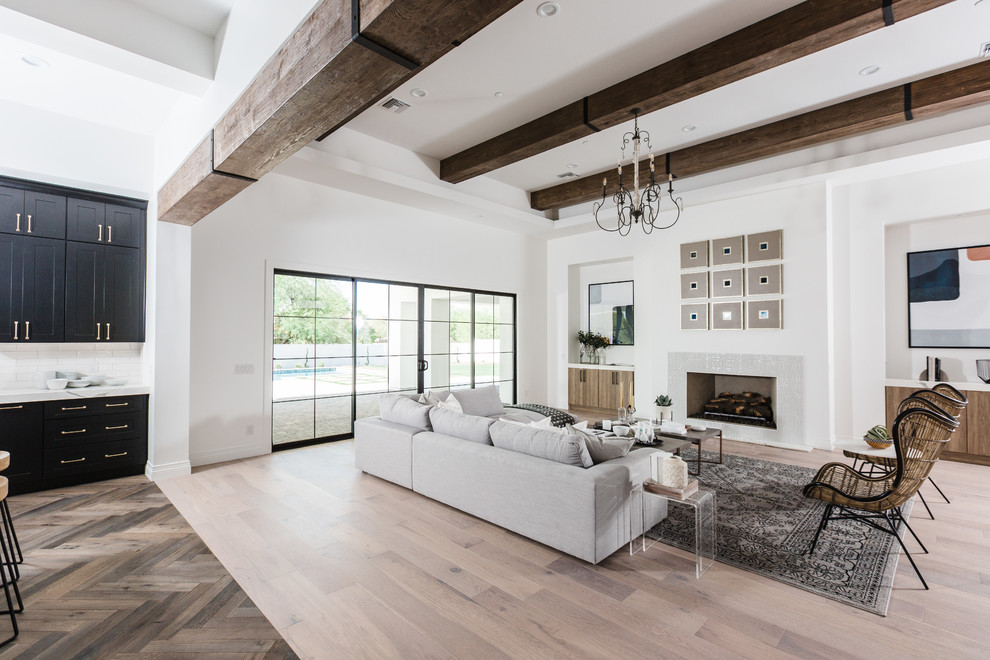 Großes, Repräsentatives, Offenes Mediterranes Wohnzimmer mit weißer Wandfarbe, hellem Holzboden, Kamin und gefliester Kaminumrandung in Phoenix