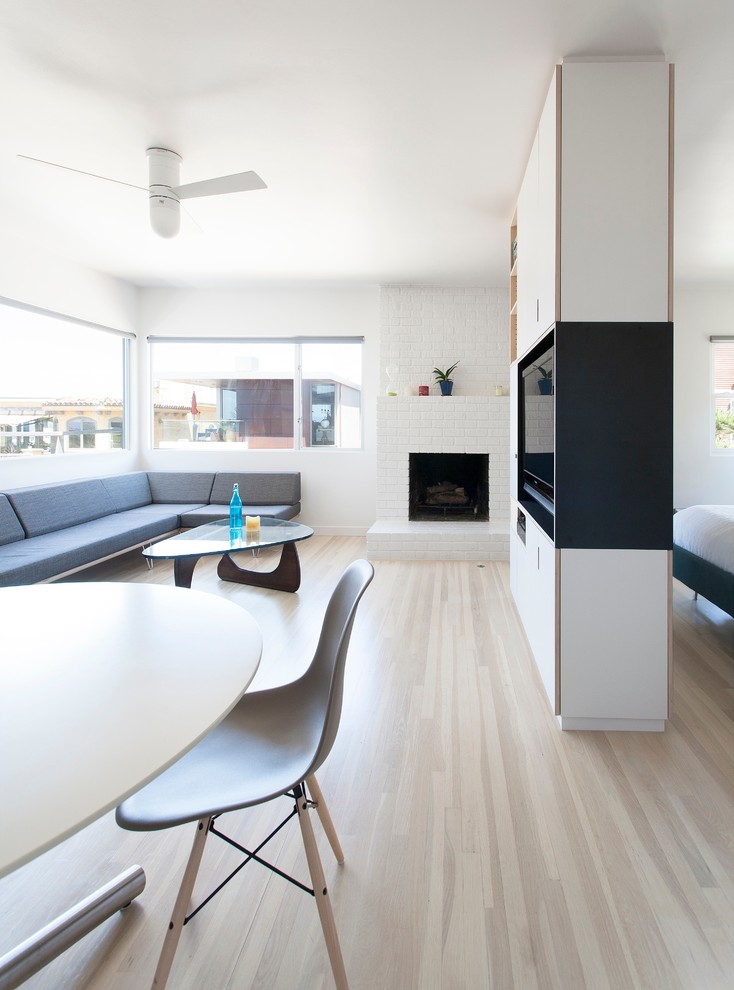 Idéer för ett modernt vardagsrum, med vita väggar och en spiselkrans i tegelsten