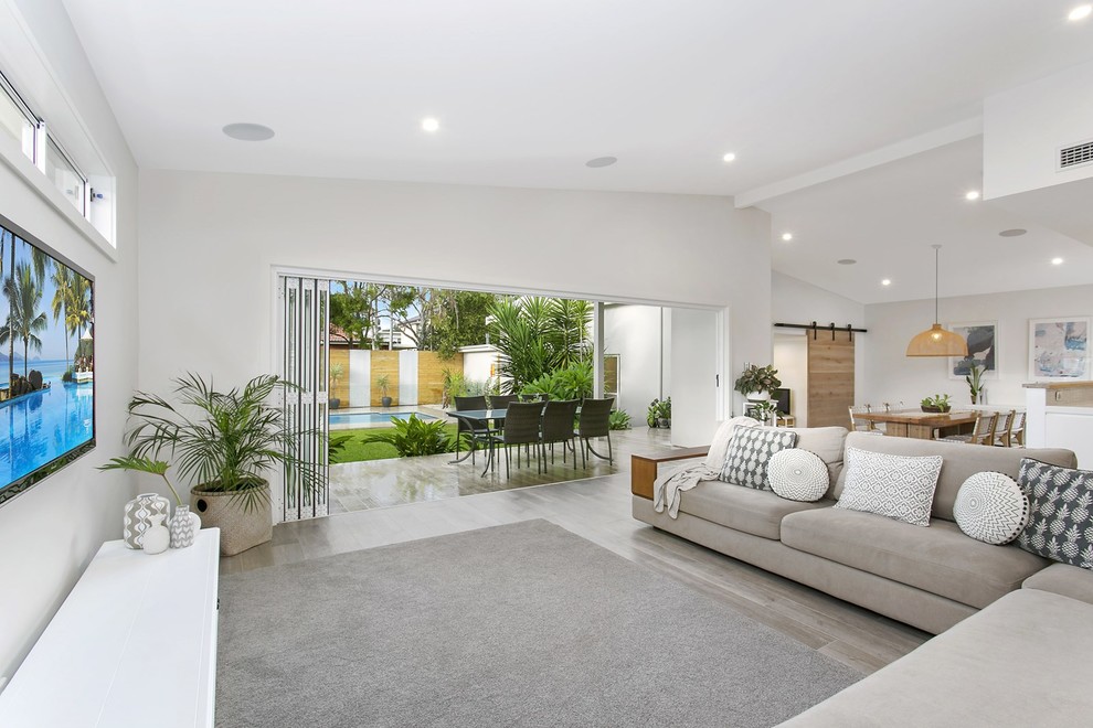 Offenes Modernes Wohnzimmer ohne Kamin mit weißer Wandfarbe und TV-Wand in Sydney