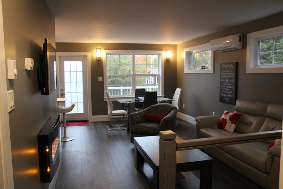 Стильный дизайн: маленькая открытая гостиная комната в современном стиле с серыми стенами, подвесным камином, телевизором на стене, полом из ламината и фасадом камина из металла для на участке и в саду - последний тренд