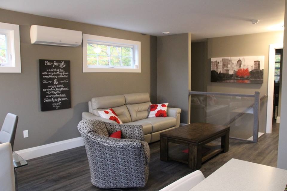 Kleines, Offenes Modernes Wohnzimmer mit grauer Wandfarbe, Hängekamin, TV-Wand, Laminat, Kaminumrandung aus Metall und grauem Boden in Sonstige