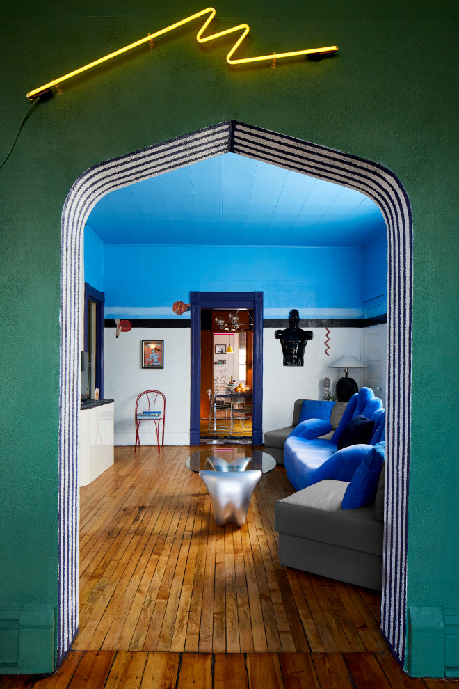 Immagine di un soggiorno eclettico di medie dimensioni e chiuso con pareti blu, parquet scuro e TV autoportante