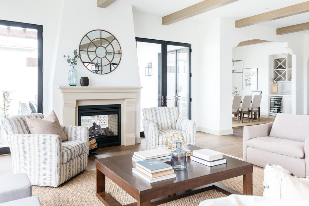Immagine di un soggiorno mediterraneo con pareti bianche, stufa a legna, pavimento marrone e parquet chiaro
