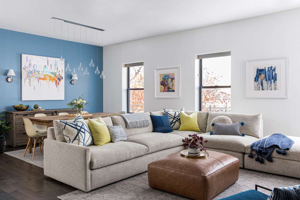 Aménagement d'un salon contemporain ouvert avec un mur bleu, parquet foncé et un sol marron.