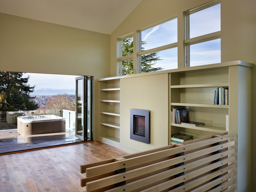 Mittelgroßes, Offenes Modernes Wohnzimmer mit grüner Wandfarbe, Kamin und Kaminumrandung aus Metall in Seattle