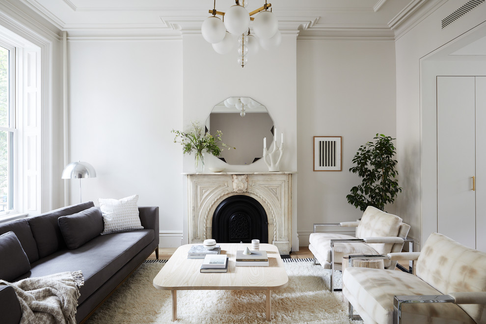 Immagine di un soggiorno chic chiuso con sala formale, pareti bianche, parquet chiaro, camino classico e nessuna TV