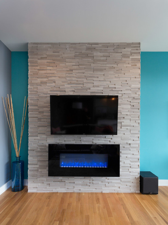 シカゴにある広いコンテンポラリースタイルのおしゃれなLDK (青い壁、無垢フローリング、横長型暖炉、石材の暖炉まわり、壁掛け型テレビ) の写真