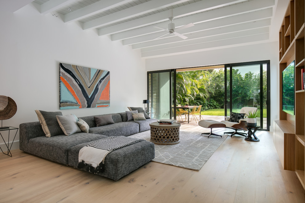 Großes, Offenes Modernes Wohnzimmer ohne Kamin mit weißer Wandfarbe, hellem Holzboden, beigem Boden und TV-Wand in Tampa