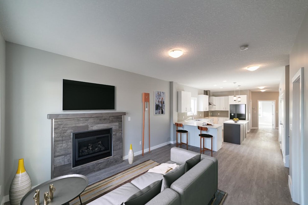 This is an example of a medium sized classic open plan living room in Edmonton with grey walls, vinyl flooring, a standard fireplace, a tiled fireplace surround and a wall mounted tv.