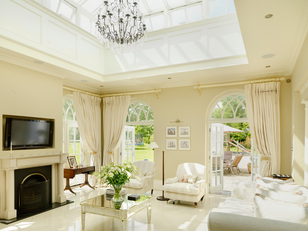 Immagine di un soggiorno tradizionale chiuso con sala formale, pareti gialle, pavimento in marmo, stufa a legna, cornice del camino in pietra e TV a parete