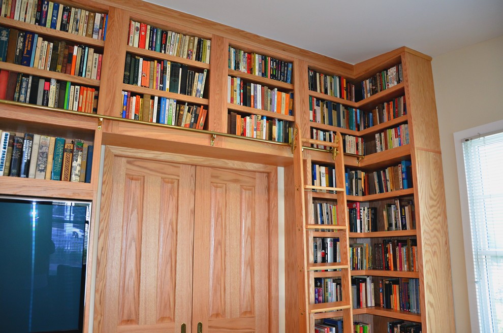 Foto di un soggiorno tradizionale di medie dimensioni e chiuso con libreria, pareti beige, parquet chiaro e parete attrezzata