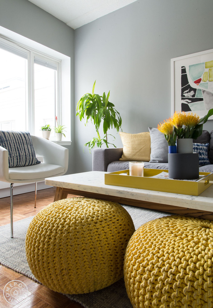 Foto di un soggiorno moderno di medie dimensioni e aperto con pareti grigie, pavimento in legno massello medio e TV a parete