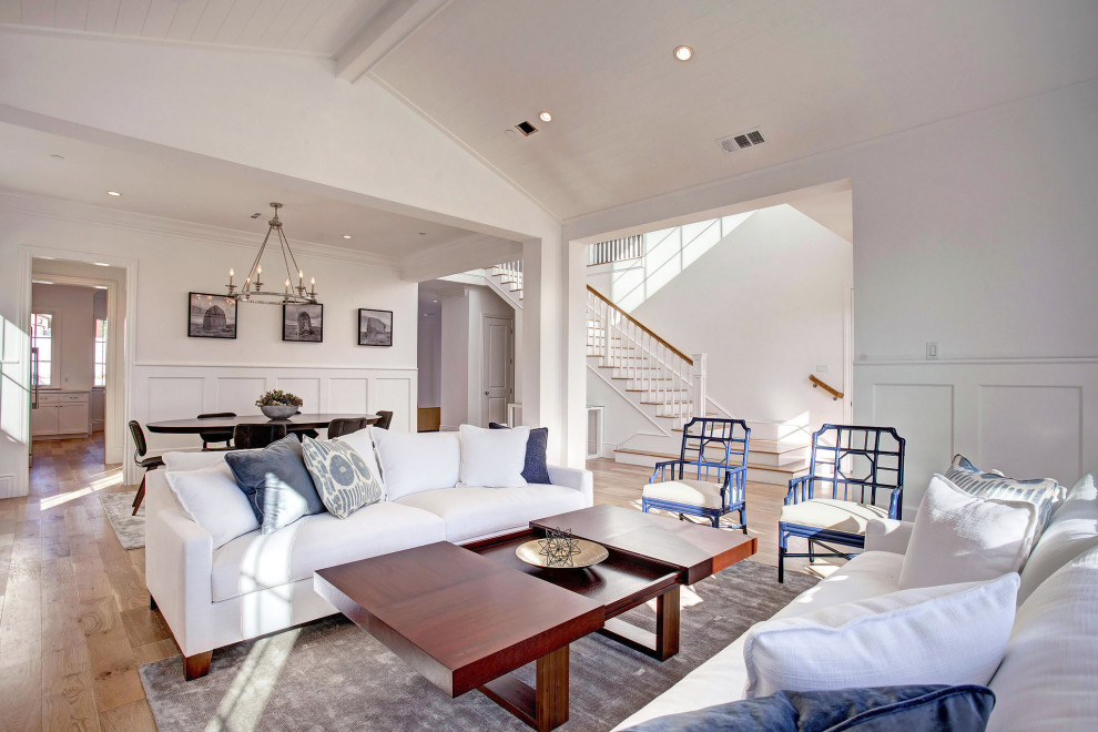 Offenes Maritimes Wohnzimmer mit weißer Wandfarbe, braunem Holzboden, braunem Boden, Holzdielendecke, gewölbter Decke und vertäfelten Wänden in Los Angeles