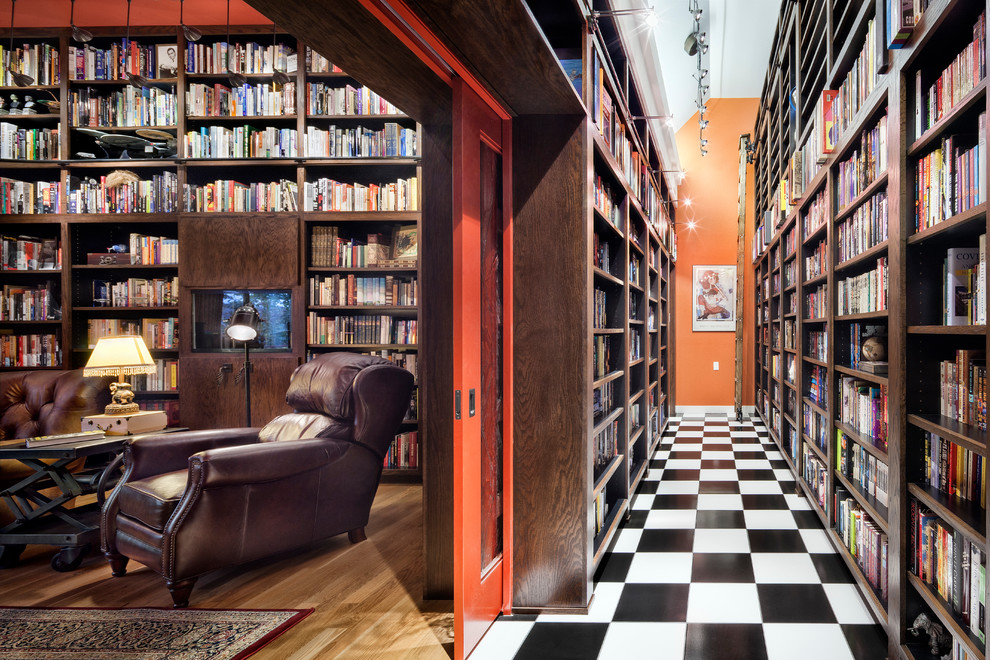 Foto di un soggiorno contemporaneo con libreria, pareti rosse e parquet chiaro