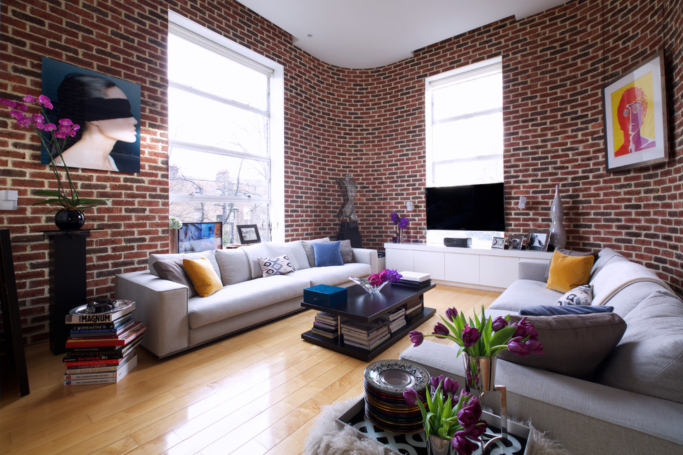 На фото: гостиная комната среднего размера в современном стиле с светлым паркетным полом и телевизором на стене с