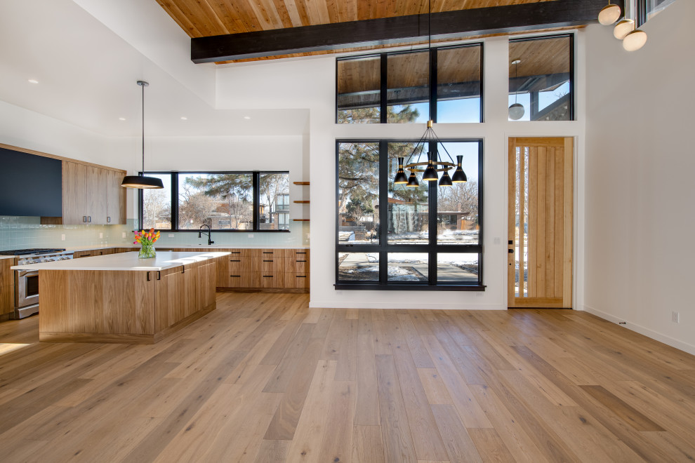 This is an example of a medium sized contemporary open plan living room in Denver with white walls, medium hardwood flooring and brown floors.