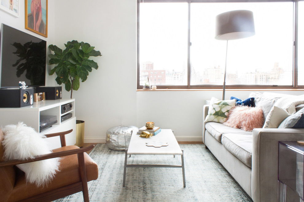 Kleines Modernes Wohnzimmer ohne Kamin, im Loft-Stil mit weißer Wandfarbe, braunem Holzboden, freistehendem TV und braunem Boden in New York