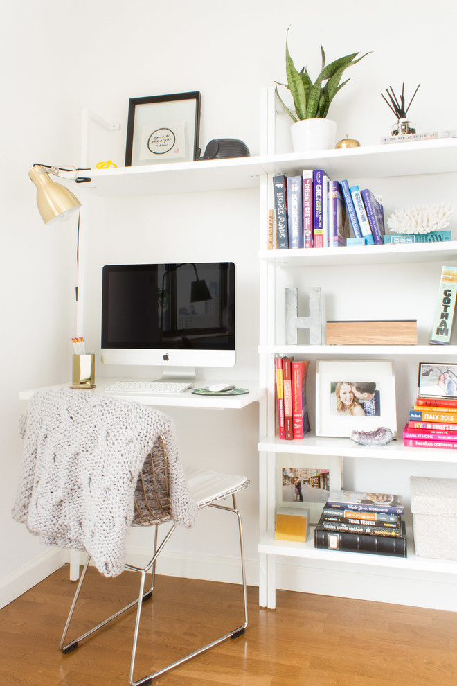 Kleines Modernes Wohnzimmer ohne Kamin mit weißer Wandfarbe, braunem Holzboden, freistehendem TV und braunem Boden in New York