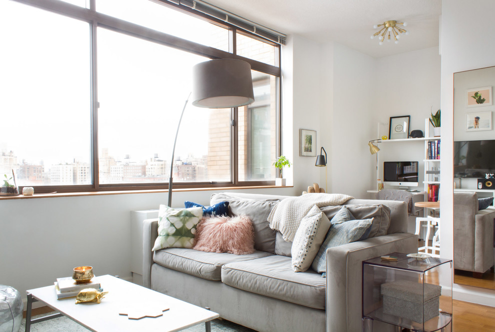Idéer för ett litet modernt loftrum, med vita väggar, mellanmörkt trägolv, en fristående TV och brunt golv