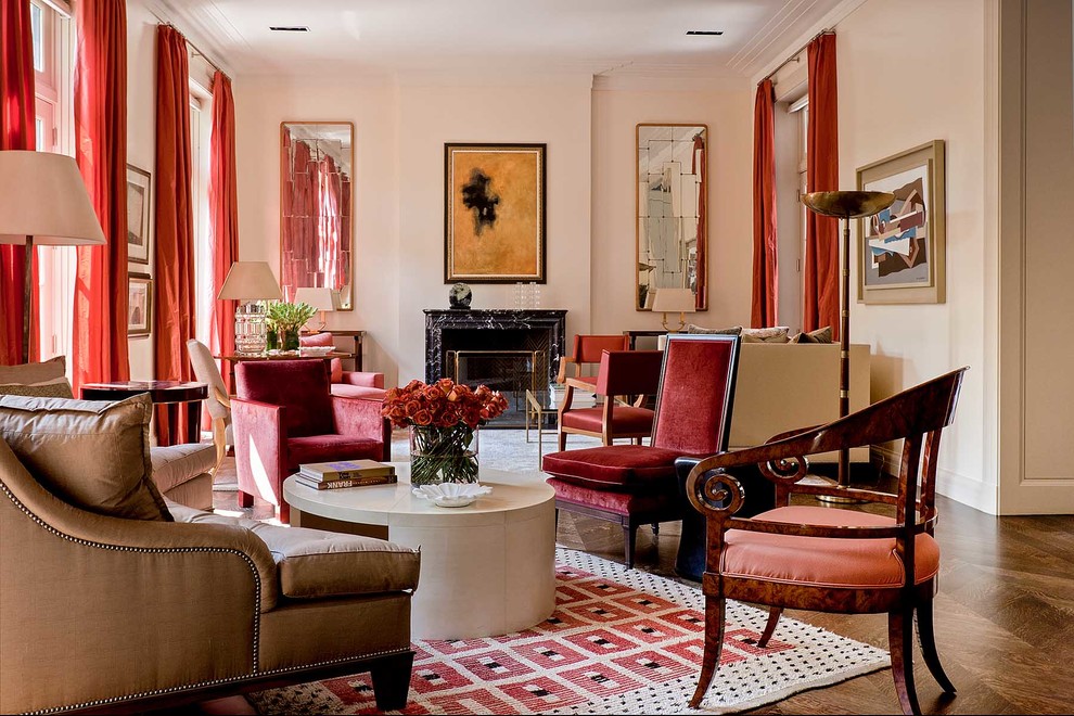 На фото: огромная гостиная комната в классическом стиле с розовыми стенами, темным паркетным полом и стандартным камином без телевизора