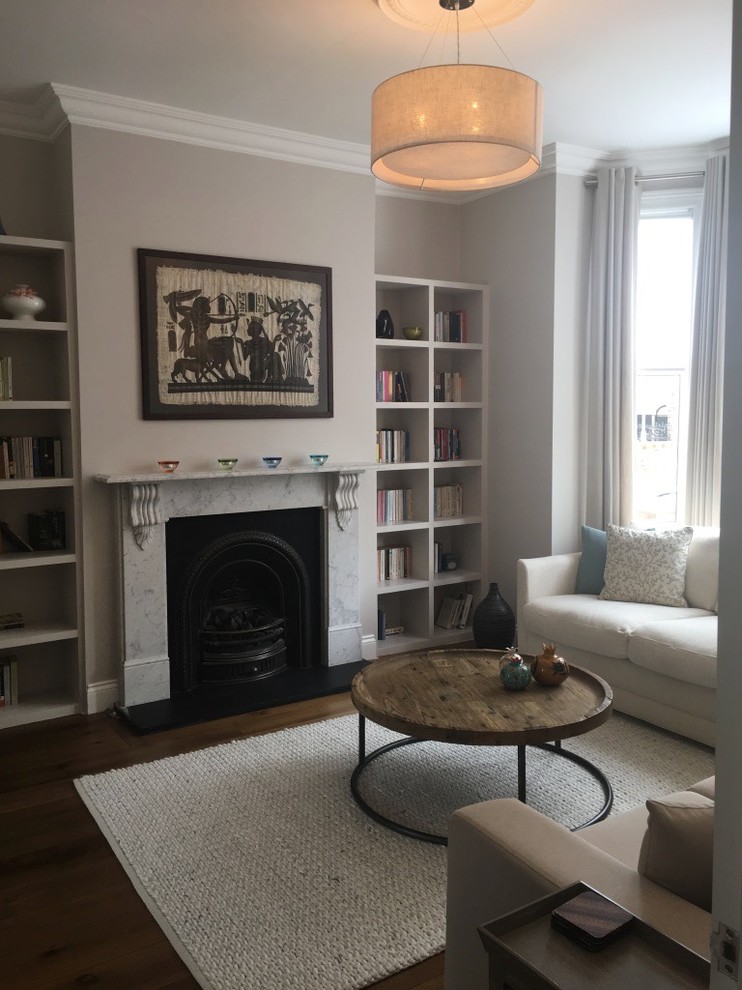 Photo of a large eclectic open plan living room in London with grey walls, medium hardwood flooring, a standard fireplace, a stone fireplace surround and brown floors.