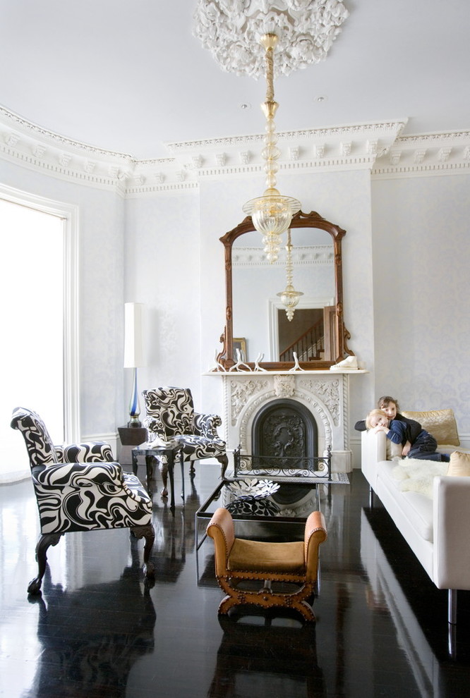 Foto på ett funkis vardagsrum, med ett finrum, vita väggar, en standard öppen spis och svart golv