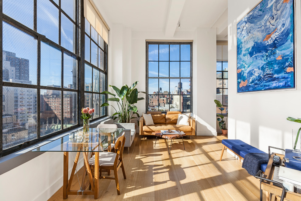 Living room - contemporary open concept light wood floor living room idea in New York with white walls