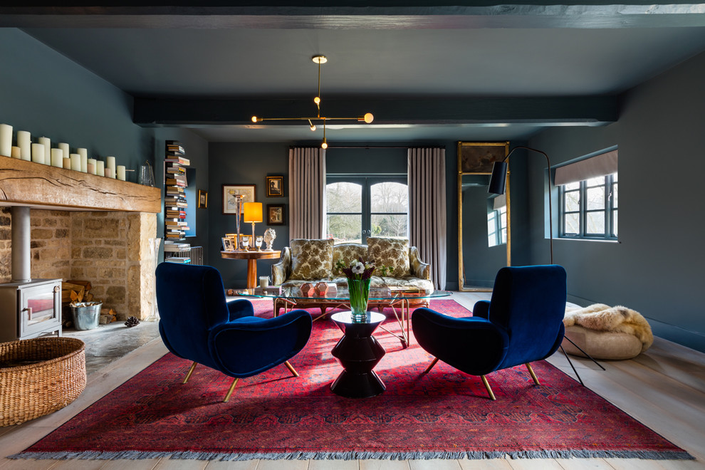 Пример оригинального дизайна: открытая, парадная гостиная комната среднего размера:: освещение в стиле модернизм с синими стенами, печью-буржуйкой, фасадом камина из камня и светлым паркетным полом