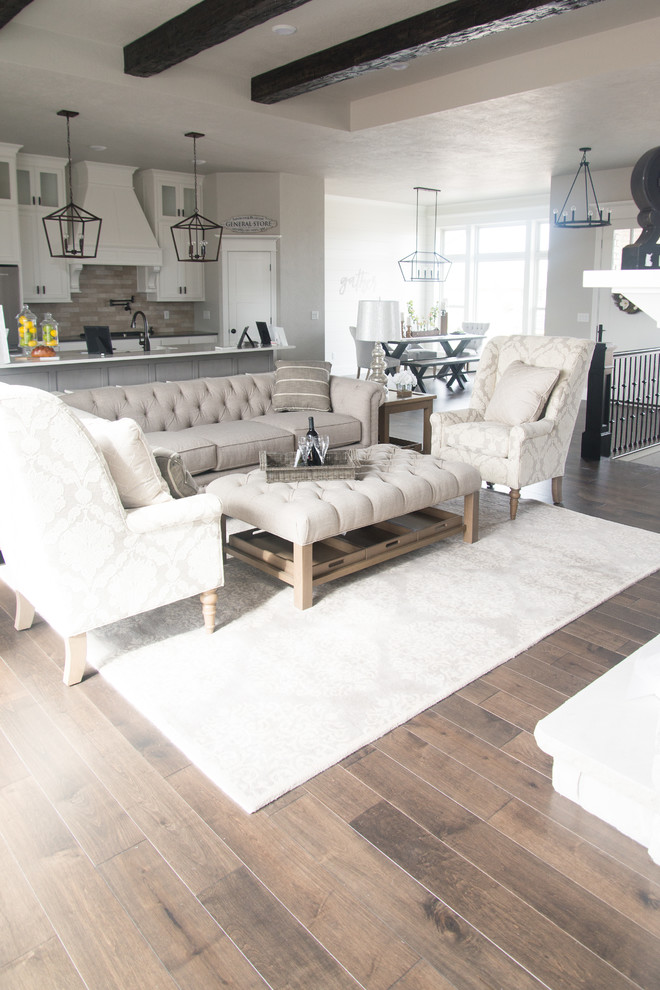 Großes, Offenes Shabby-Style Wohnzimmer mit braunem Holzboden, braunem Boden und grauer Wandfarbe in Sonstige