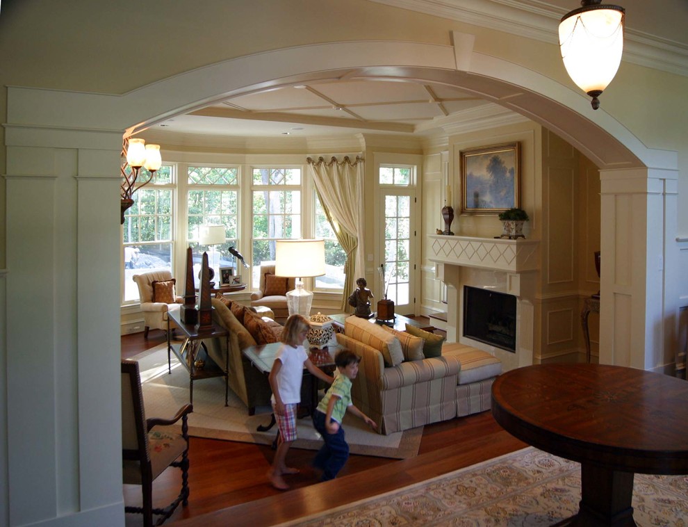 Пример оригинального дизайна: парадная, открытая гостиная комната в классическом стиле с бежевыми стенами, паркетным полом среднего тона, стандартным камином и фасадом камина из камня без телевизора